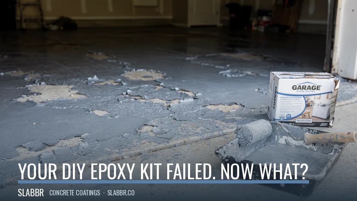 Failed DIY epoxy kit flaking off a garage floor next to a paint roller